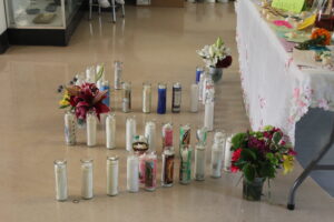 Bouquets, candles, and written messages for the late BHS students fill the gallery space in the C-Building.